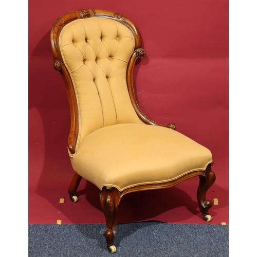 934 - A Victorian walnut spoon back nursing chair with overstuffed seat and button back, cabriole legs on ... 