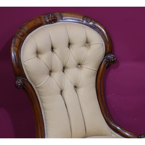 934 - A Victorian walnut spoon back nursing chair with overstuffed seat and button back, cabriole legs on ... 