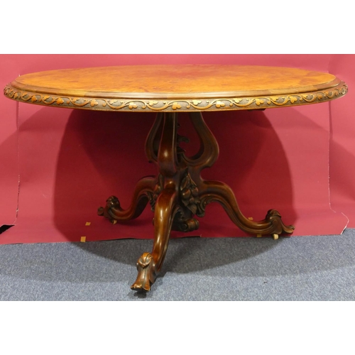 936 - A Victorian bur walnut round tilt-top breakfast table with carved floral and scroll rim, tri-pod bas... 