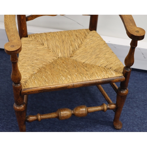 1003 - A 19th Century oak wavy ladder back armchair with rush seat, 116cm high,  59cm wide overall, 46cm de... 