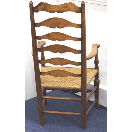 1003 - A 19th Century oak wavy ladder back armchair with rush seat, 116cm high,  59cm wide overall, 46cm de... 