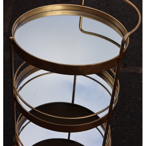 1025 - A retro gilt metal 3-tierd drinks trolley on castors with mirrored shelves, 96cm high overall, 56.5c... 