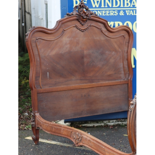 1027 - A Continental walnut French style carved bed with headboard, footboard and side panels, headboard he... 