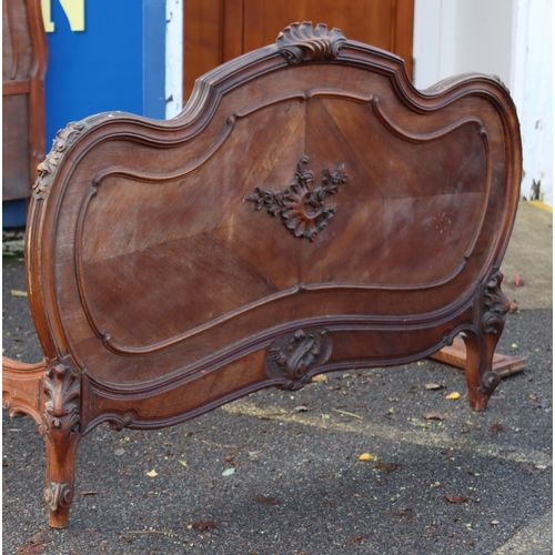 1027 - A Continental walnut French style carved bed with headboard, footboard and side panels, headboard he... 