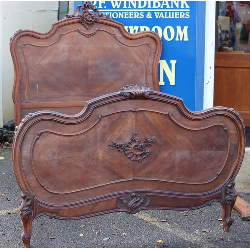 1027 - A Continental walnut French style carved bed with headboard, footboard and side panels, headboard he... 