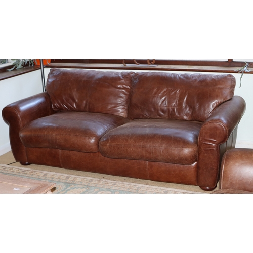 1039 - A brown 3- seater leather sofa, 2 base cushions, 2 back cushions with velcro fittings, on wood bun f... 