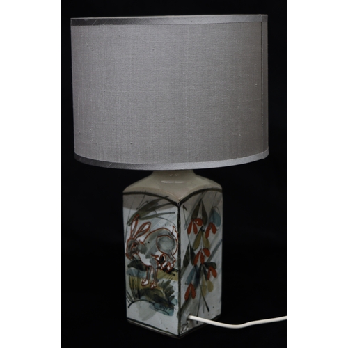 1076 - A Colin Kellam Studio Pottery lamp depicting hares, with grey shade, 43cm high overall.