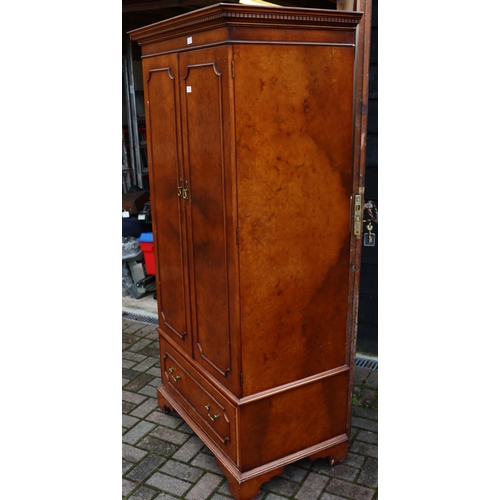 1104 - A good quality reproduction walnut double wardrobe with key pattern cornice, 2 panel doors enclosing... 