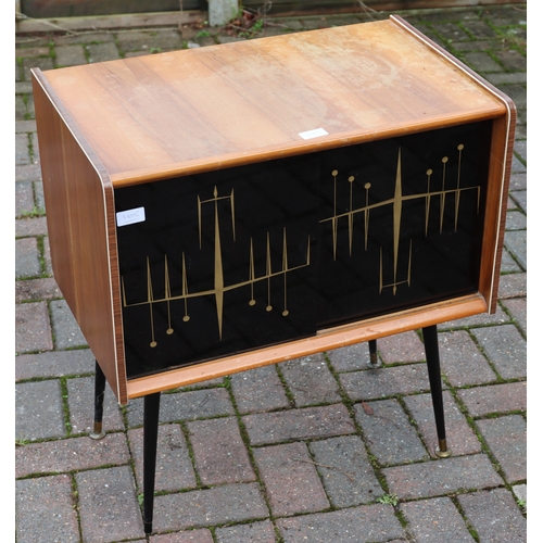 1105 - A 1950's teak low cabinet with black gloss sliding doors. gilt decoration, on round tapering legs, 6... 