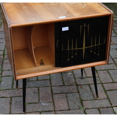 1105 - A 1950's teak low cabinet with black gloss sliding doors. gilt decoration, on round tapering legs, 6... 