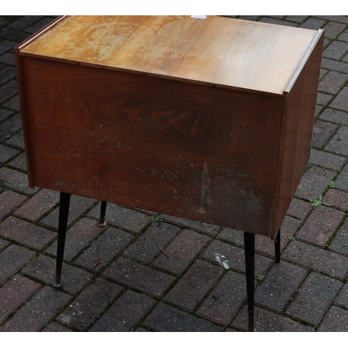 1105 - A 1950's teak low cabinet with black gloss sliding doors. gilt decoration, on round tapering legs, 6... 