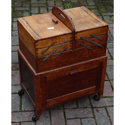 1108 - An oak work box with double hinged expanding top over 2 panel doors, on castors, 51cm wide closed, 3... 