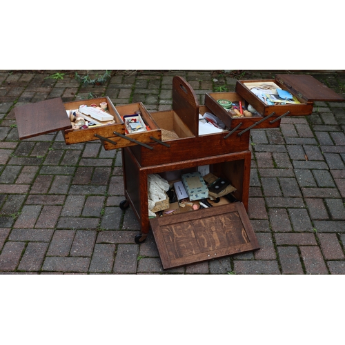 1108 - An oak work box with double hinged expanding top over 2 panel doors, on castors, 51cm wide closed, 3... 