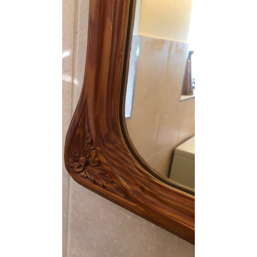 1147 - A wood framed mirror with carved floral pattern to base corners, 75cm wide, 100cm high. This Lot is ... 