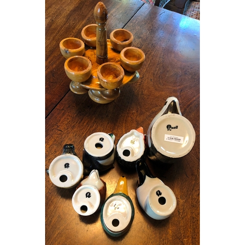 1189 - 6 novelty egg cups and 1 mug in the shape of animal heads and a wooden stand with 6 wooden egg cups.