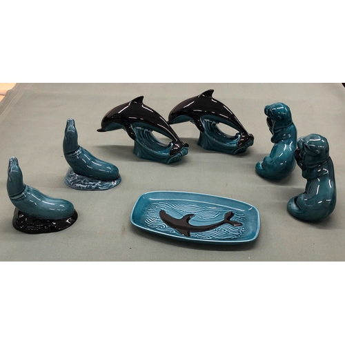 1222 - A quantity of Poole Pottery, 2 dolphins, 2 seals, 2 otters and a plate.