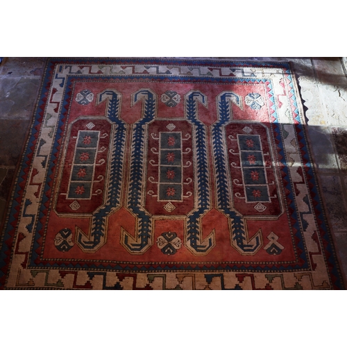 1276 - A square rug on red, blue and cream ground with tassels, 200 x 196cm.