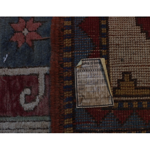 1276 - A square rug on red, blue and cream ground with tassels, 200 x 196cm.