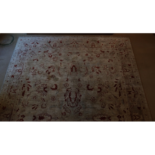 1281 - A dark cream and red rug with tassels, 274 x 182cm.