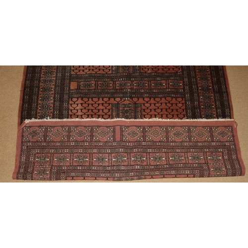 1283 - A rug on red and grey ground with tassels, 181 x 128cm