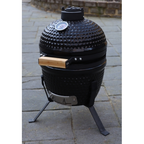 1286 - A small black egg style barbeque on metallic stand, matching hinged lid, ceramic interior with grill... 