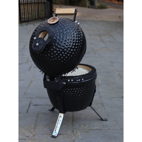 1286 - A small black egg style barbeque on metallic stand, matching hinged lid, ceramic interior with grill... 