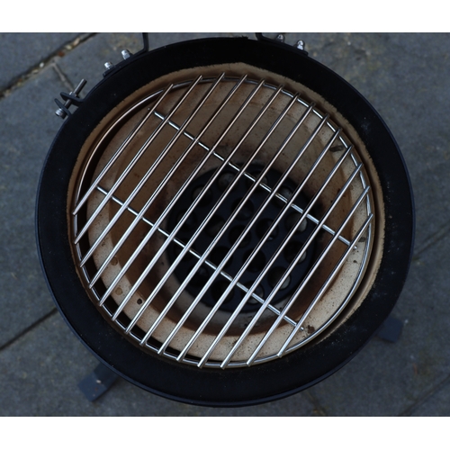 1286 - A small black egg style barbeque on metallic stand, matching hinged lid, ceramic interior with grill... 