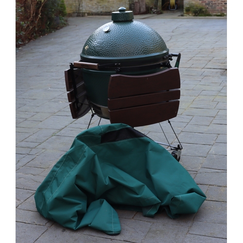 1287 - A Big Green Egg barbeque on wheels, 137cm high overall, 2 drop-down side shelves,  griddle pan and g... 