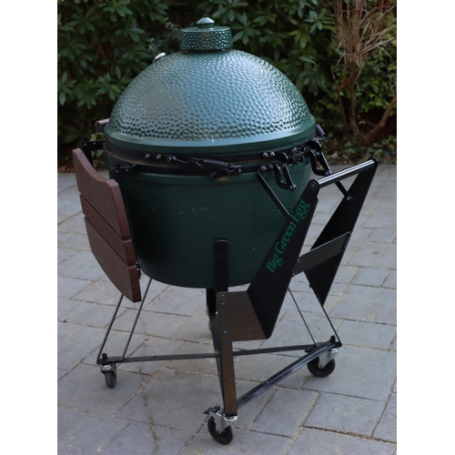 1287 - A Big Green Egg barbeque on wheels, 137cm high overall, 2 drop-down side shelves,  griddle pan and g... 