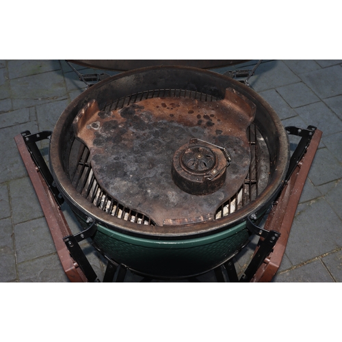 1287 - A Big Green Egg barbeque on wheels, 137cm high overall, 2 drop-down side shelves,  griddle pan and g... 