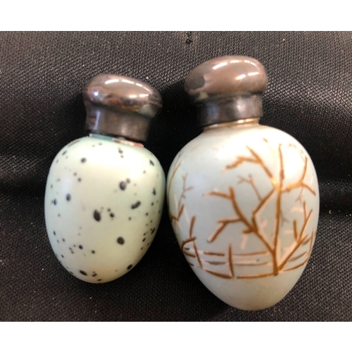 1220 - 2 miniature egg shaped painted scent bottles with silver screw lids.