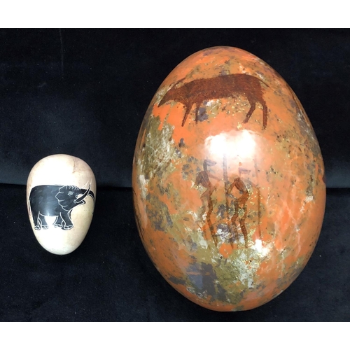 1247 - A painted ostrich egg and a stone egg with elephant decoration