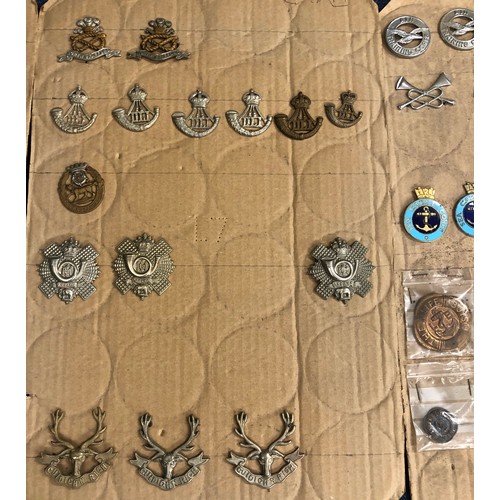 845 - A quantity of various military and other cap badges etc mounted on 10 boards