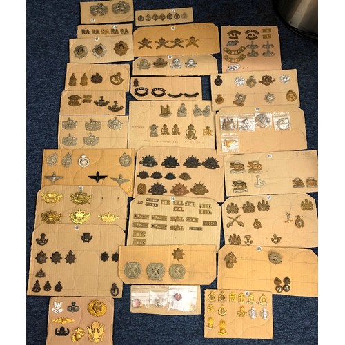 846 - A quantity of various military and other cap badges etc mounted on 26 cut down boards