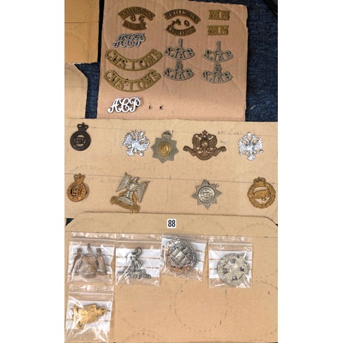 846 - A quantity of various military and other cap badges etc mounted on 26 cut down boards