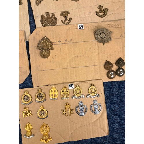 846 - A quantity of various military and other cap badges etc mounted on 26 cut down boards