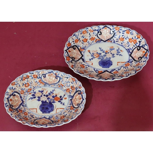 107 - An Imari oval scallop shaped dish on white, red and blue ground with vase, floral and leaf decoratio... 