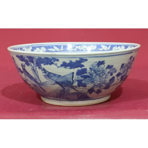 109 - An Oriental blue and white round trumpet shaped bowl with bird, branch, floral and leaf decoration, ... 