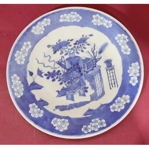 110 - An Oriental blue and white round dish with vase, stand, floral and leaf decoration, 30cm diameter