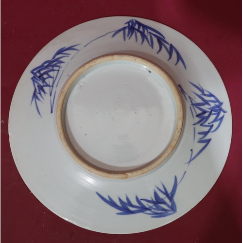 110 - An Oriental blue and white round dish with vase, stand, floral and leaf decoration, 30cm diameter