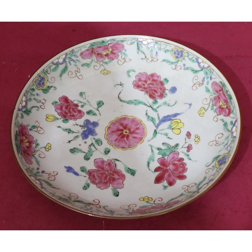 113 - An 18th Century Oriental round plate on white ground with pink, green, yellow and blue floral, leaf ... 