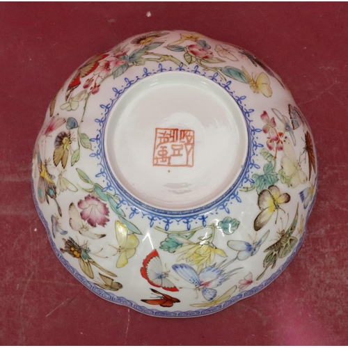 115 - An Oriental 20th Century round scallop shaped bowl on white and blue ground with multicoloured butte... 