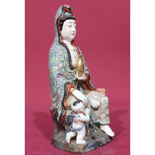 123 - An Oriental glazed earthenware figure of a seated goddess with child at her feet, 28.5cm high