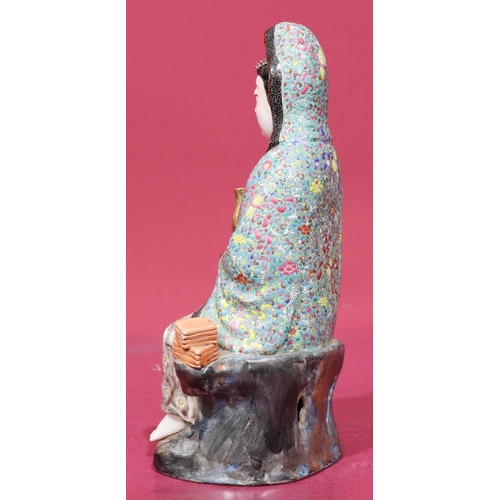 123 - An Oriental glazed earthenware figure of a seated goddess with child at her feet, 28.5cm high