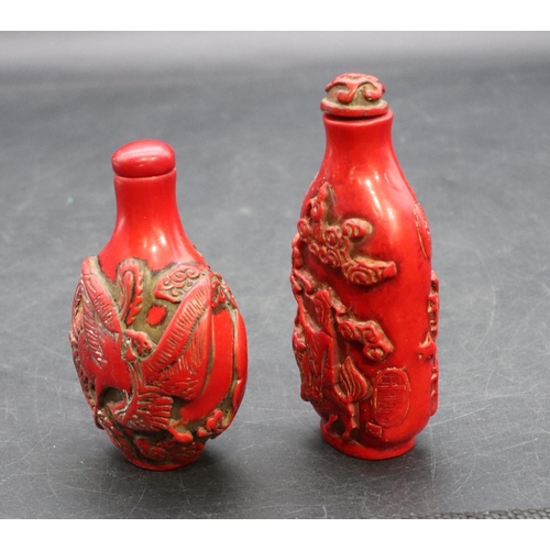 124 - 2 Oriental red snuff bottles with raised dragon and figure decoration (2)