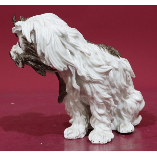 169 - A Continental Meissen style figure of a seated shaggy dog on white and brown ground, 20cm high (slig... 