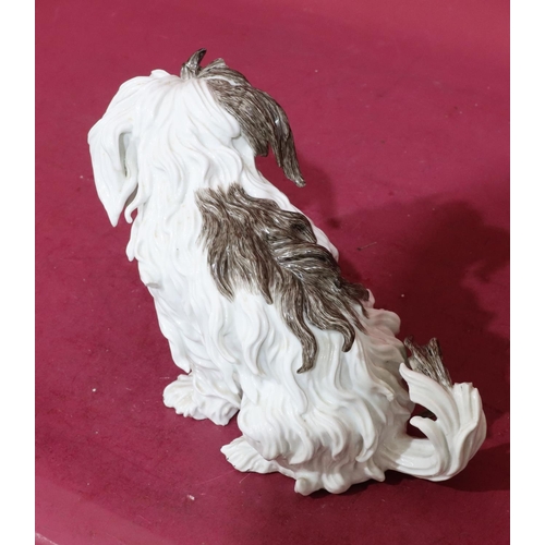 169 - A Continental Meissen style figure of a seated shaggy dog on white and brown ground, 20cm high (slig... 