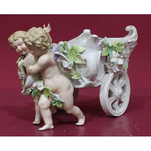 185 - A 19th Century Continental china comport in the form of 2 cupids pulling a chariot with encrusted fl... 