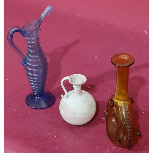 209 - An early glass bulbous shaped jug with scroll handle, 12.5cm high, a blue glass jug with raised ring... 