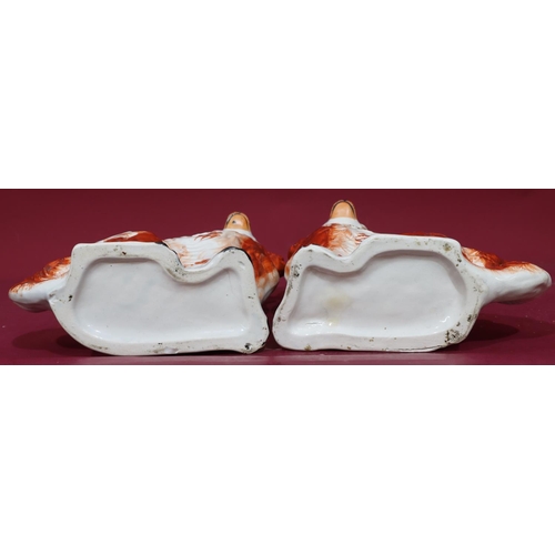 215 - A pair of 19th Century Staffordshire figures of seated spaniels on white and red ground with gilt ch... 